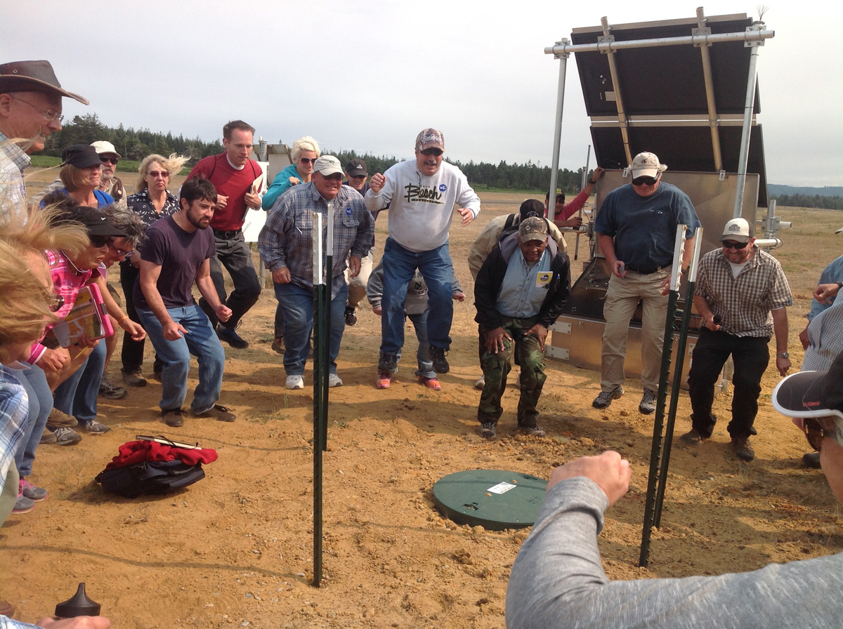 Coos Bay workshop participants jump next to a seismic station to make a local "earthquake"